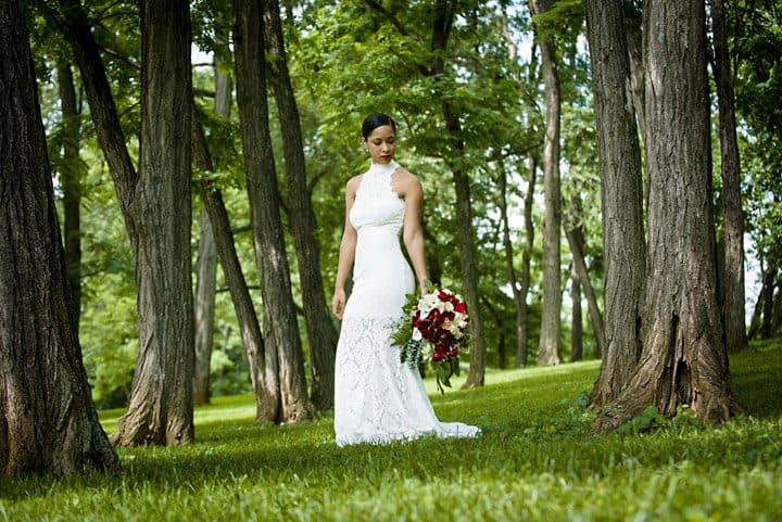 Bride portrait in a grove of trees looking at her bouquet
