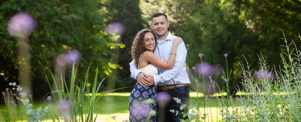 engagement session posing between purple flowers