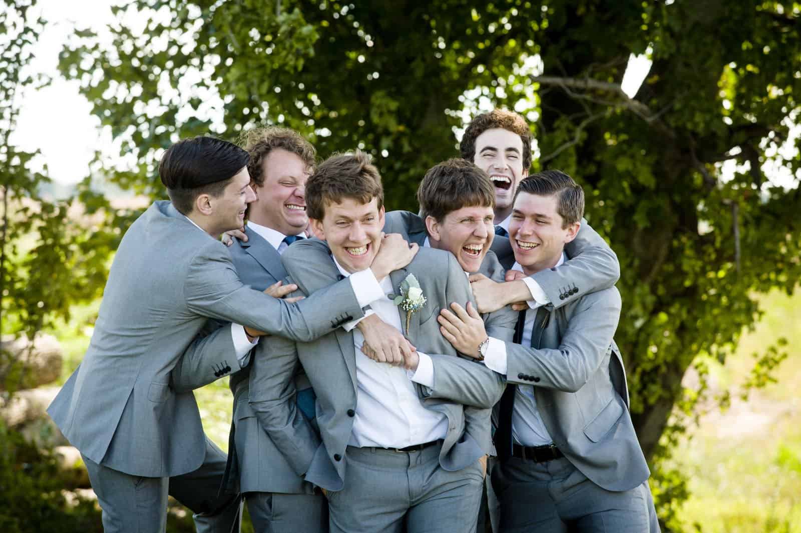Groomsman hugging groom at Thousand Acre Farm in Delaware