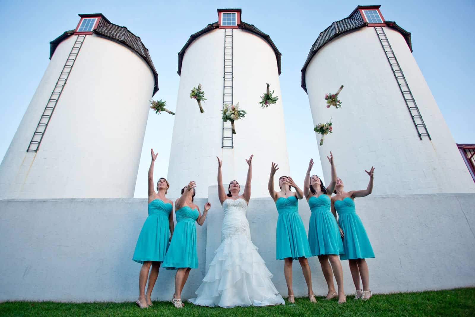 Bridesmaid group throwing flowers in the air at Normandy Farm