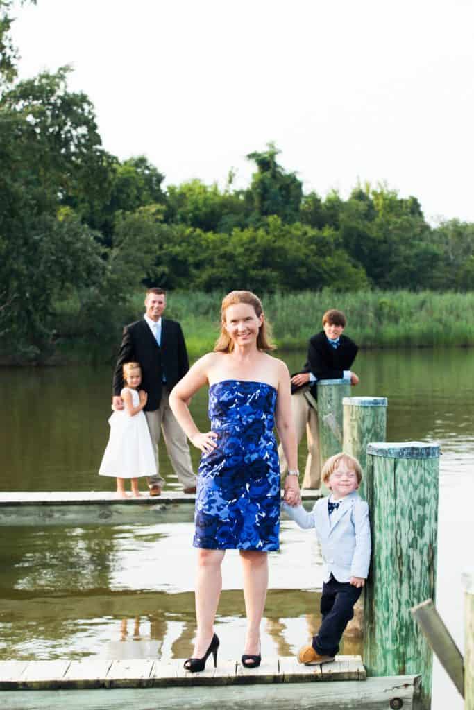 mom with son on a dock with dad behind