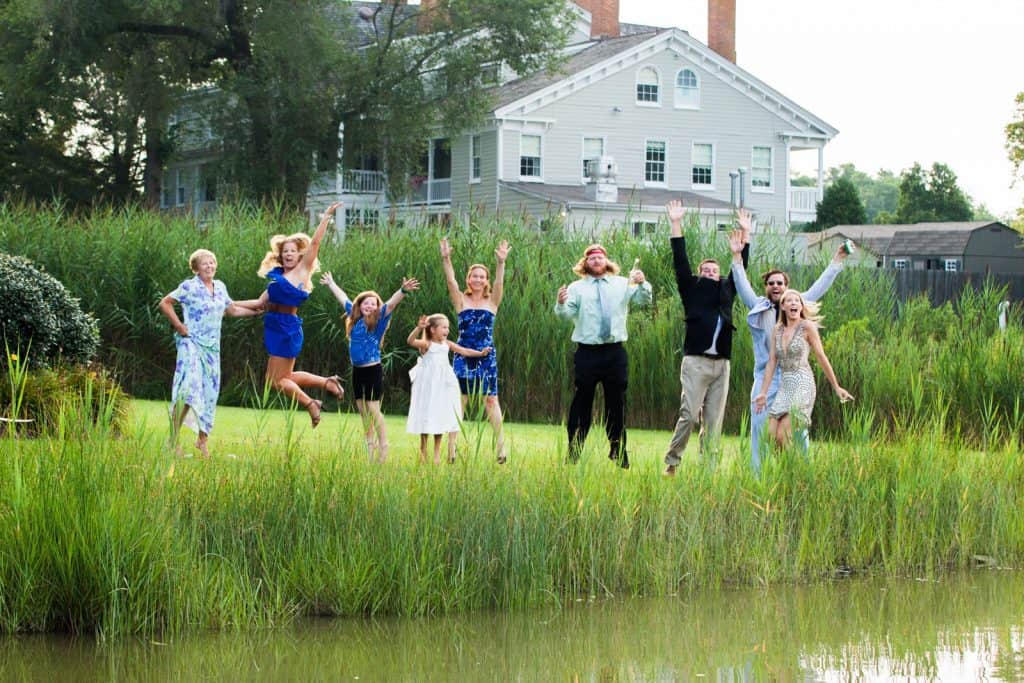 family jumping in the air at a lake